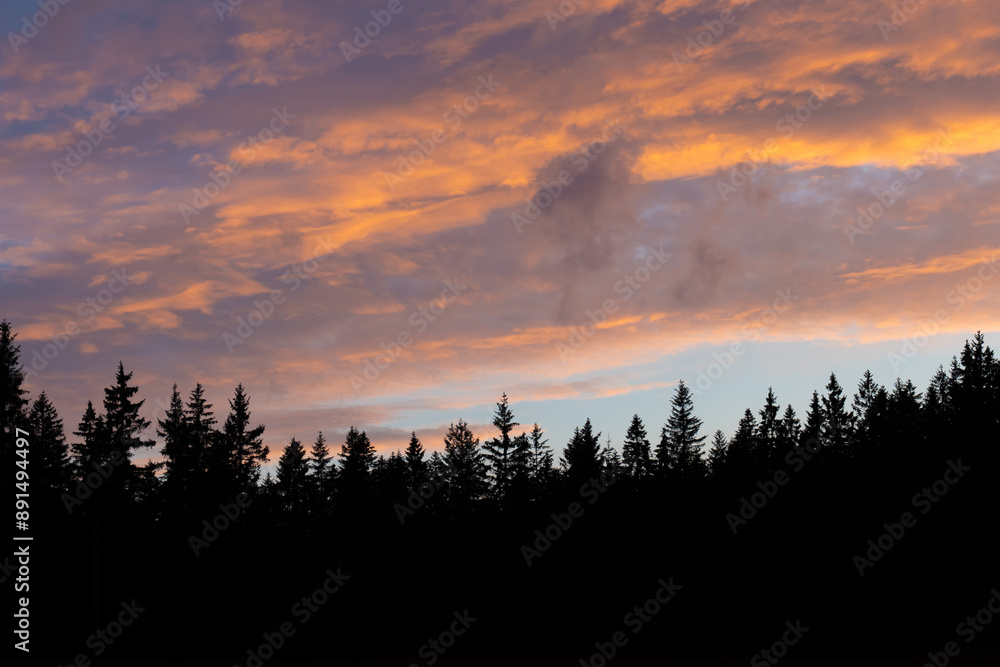 Beautiful sunset over forest silhouette with vibrant orange and purple clouds on a serene evening. Concept of nature's beauty, tranquil moments, and scenic landscapes. High quality photo Beautiful sunset over forest silhouette with vibrant orange and purple clouds on a serene evening. Concept of nature's beauty, tranquil moments, and scenic landscapes. High quality photo