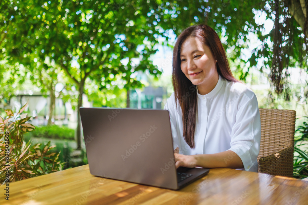 Portrait image of a woman working on laptop computer in the outdoors Portrait image of a woman working on laptop computer in the outdoors