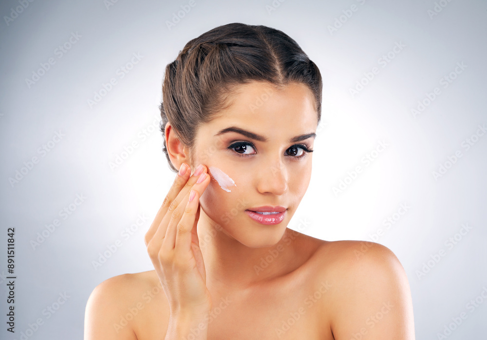 Skincare, portrait and woman in studio with lotion, cosmetics and make up foundation. Dermatology, female person and facial care on gray background with moisturizer, cream and treatment for soft skin Skincare, portrait and woman in studio with lotion, cosmetics and make up foundation. Dermatology, female person and facial care on gray background with moisturizer, cream and treatment for soft skin
