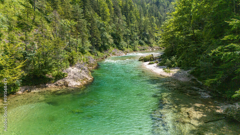 Drohnenaufnahme von türkis grünem Gebirgsfluss, Fluss fließt im Frühsommer durch eine Engstelle im Wald Drohnenaufnahme von türkis grünem Gebirgsfluss, Fluss fließt im Frühsommer durch eine Engstelle im Wald