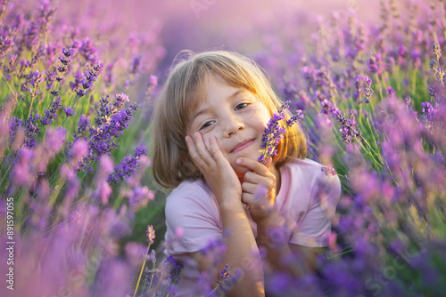 Cute little girl sitting at lavender meadow.