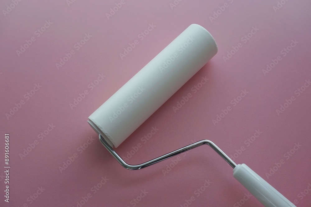 Sticky roller lint remover for clothes on pink background Sticky roller lint remover for clothes on pink background