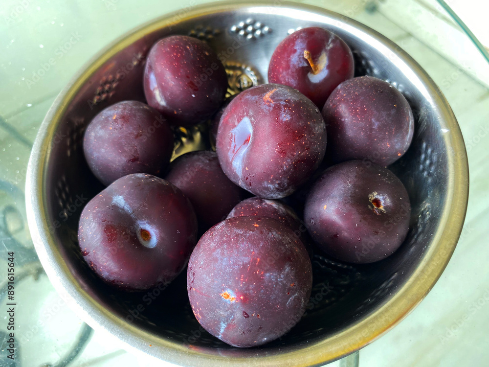 A close-up of ripe plums nestled in a bowl, showcasing their deep purple skin and juicy, vibrant interiors. A close-up of ripe plums nestled in a bowl, showcasing their deep purple skin and juicy, vibrant interiors.