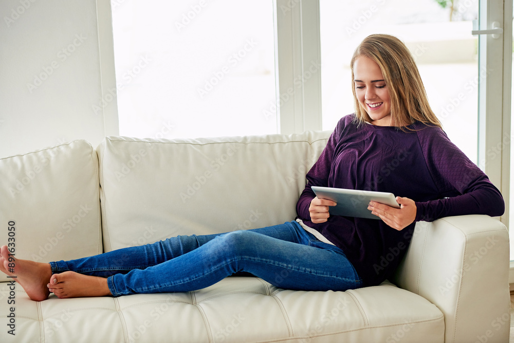 Woman, home and relaxing on sofa with tablet for social media, online post and watch videos for fun. Female person, couch and smile or laugh in lounge for entertainment, streaming service and website Woman, home and relaxing on sofa with tablet for social media, online post and watch videos for fun. Female person, couch and smile or laugh in lounge for entertainment, streaming service and website