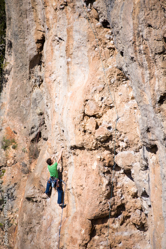 A rock climber climbs to the top along a difficult route. 