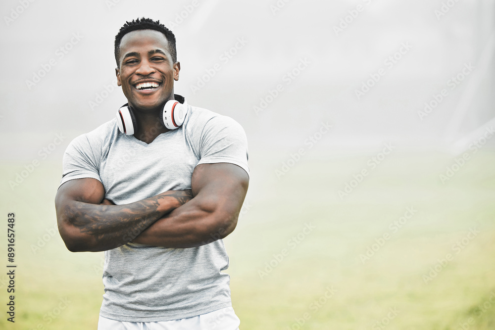 Fototapeta premium Black man, portrait and confidence outdoor for fitness, wellness and health goals achievement in morning. Athlete, face and crossed arms on field for workout, training and exercise with headphones