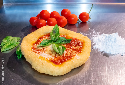 Neapolitan fried pizza with tomato sauce cheese and basil leaves, called Montanara photo