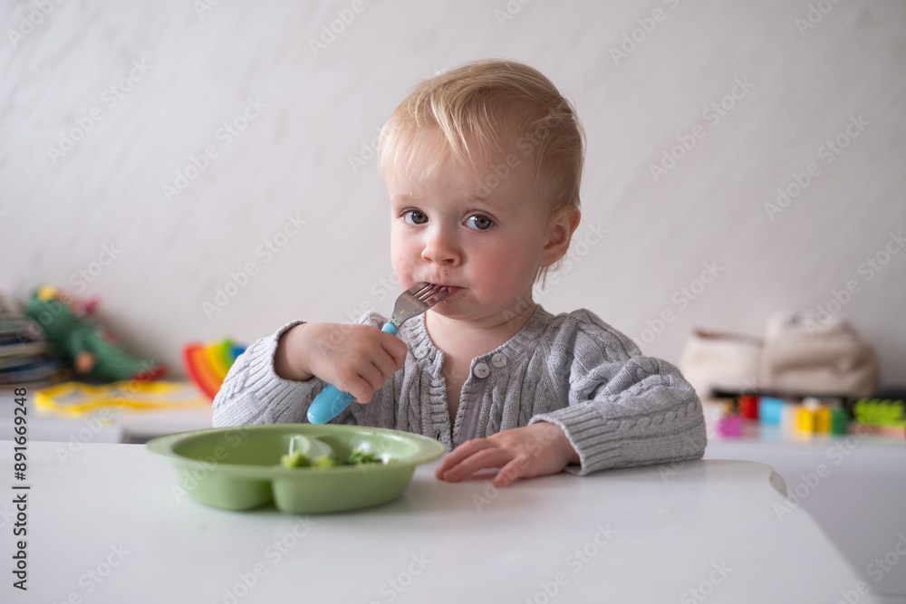 Child little girl eats vegetable salad using fork Child little girl eats vegetable salad using fork