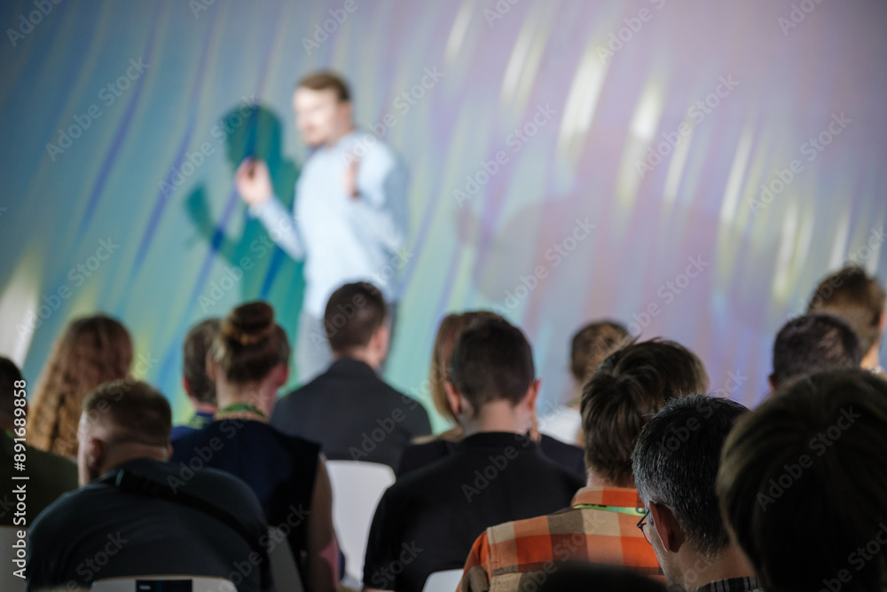Obraz premium Group of people listens intently to a presenter during a business conference, highlighting concepts of learning and professional development.