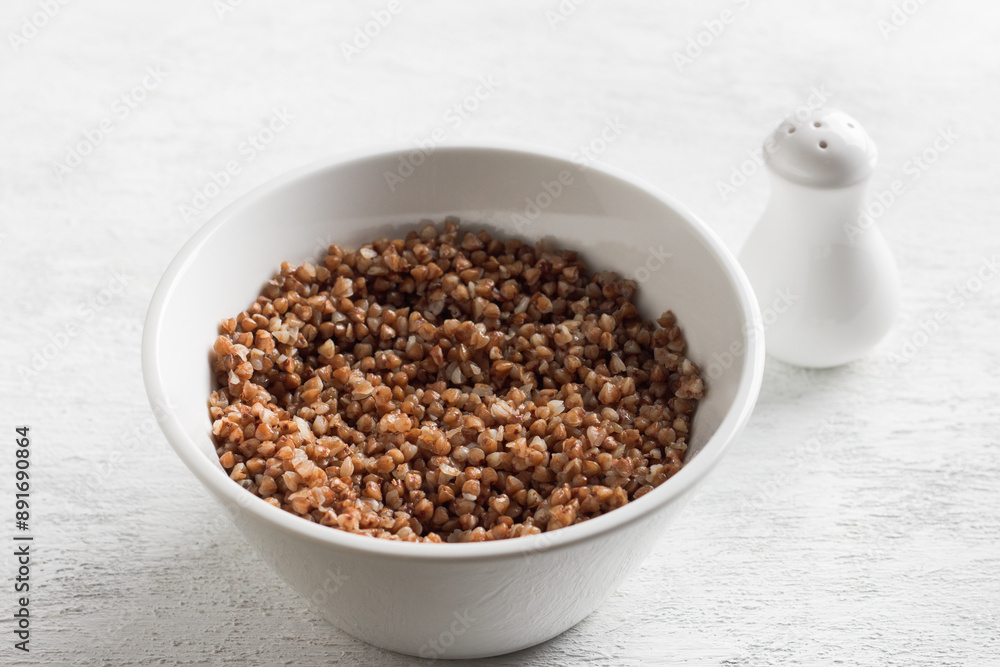 Bowl with boiled buckwheat on a white background. healthy homemade food Bowl with boiled buckwheat on a white background. healthy homemade food