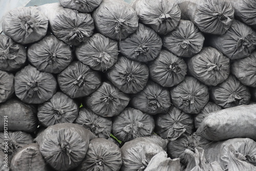 pile of bags of charcoal used for traditional charcoal burning out in the Bieszczady Mountains in Szczerbanówka in black and white photo