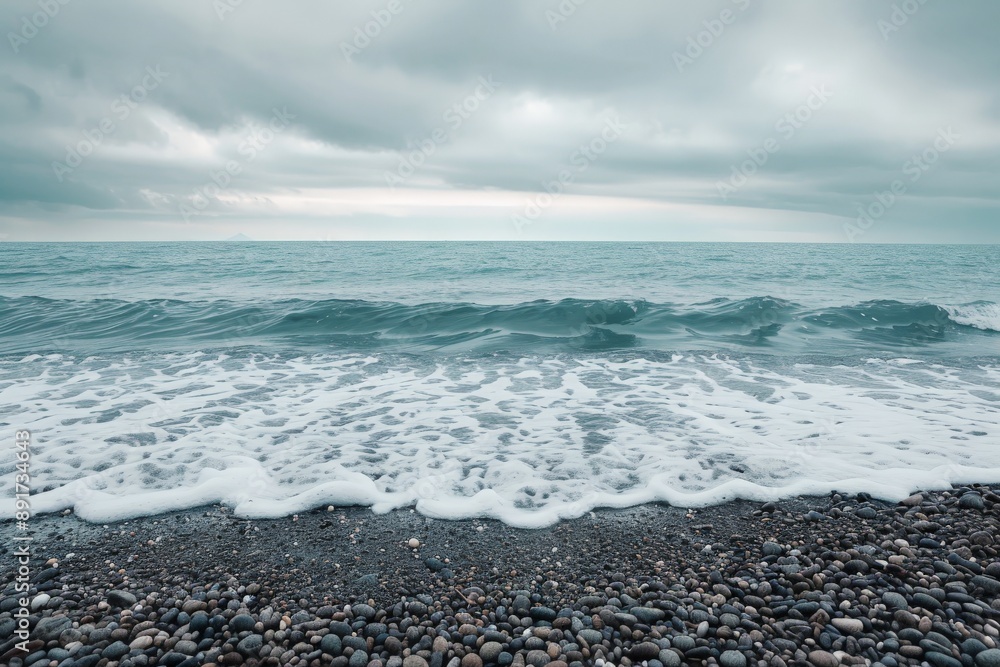 Waves gently roll onto a rocky shore under a cloudy sky, creating a scene that combines the power of the ocean with a peaceful ambiance, symbolizing harmony. Waves gently roll onto a rocky shore under a cloudy sky, creating a scene that combines the power of the ocean with a peaceful ambiance, symbolizing harmony.