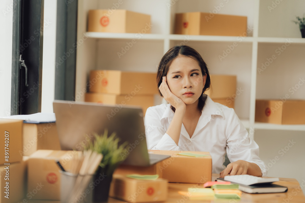 Young asian woman ecommerce SME business stressed leaning on package at home office, stressed headache Startup small business entrepreneur asian Young asian woman ecommerce SME business stressed leaning on package at home office, stressed headache Startup small business entrepreneur asian