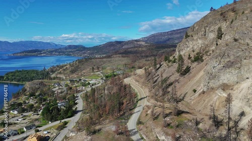 Aerial view (tilt up / pan right) of Westside Road near Okanagan Lake during a spring season in West Kelowna, British Columbia, Canada