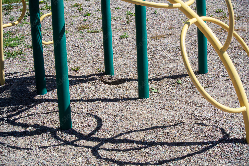 Shadow of the circular climbing structure on a park playground set Shadow of the circular climbing structure on a park playground set