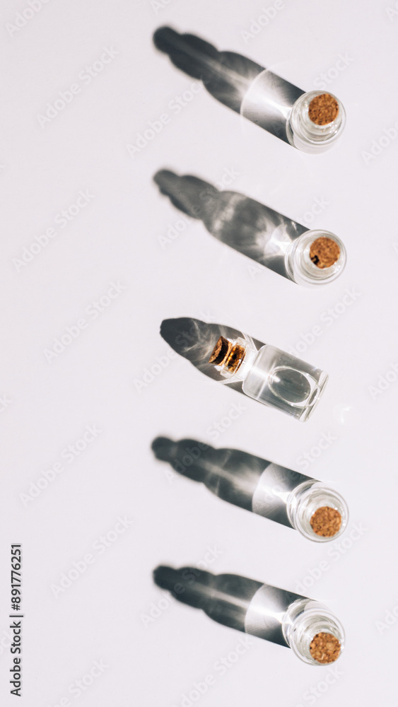 line of tiny glass jars on the sun light on white background line of tiny glass jars on the sun light on white background