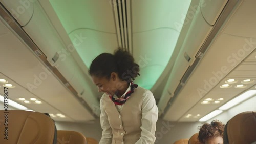 Air hostess walk to close luggage compartment of airplane and service custormer before take off and bring the passenger to the destination with happiness.