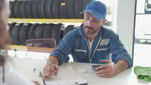 Young woman payment with a credit card in car repair shop. Payment by credit card.