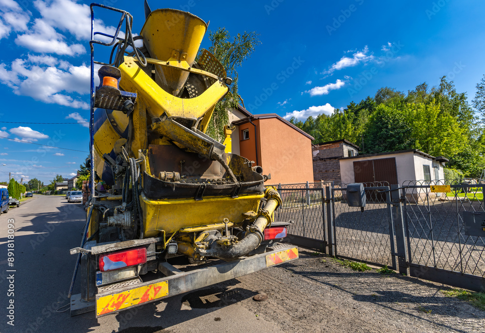 A concrete mixer feeds concrete into the screed when building a house A concrete mixer feeds concrete into the screed when building a house