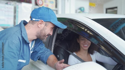 Male car mechanic explaining car maintenance. Auto mechanic and a female customer.