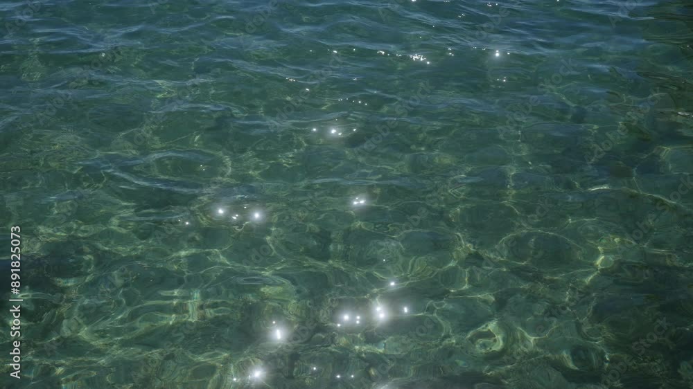 Sunlight sparkles on the clear green waters of porto cesareo, salento, italy, showcasing the beauty of the serene ocean waves under bright daylight. Sunlight sparkles on the clear green waters of porto cesareo, salento, italy, showcasing the beauty of the serene ocean waves under bright daylight.