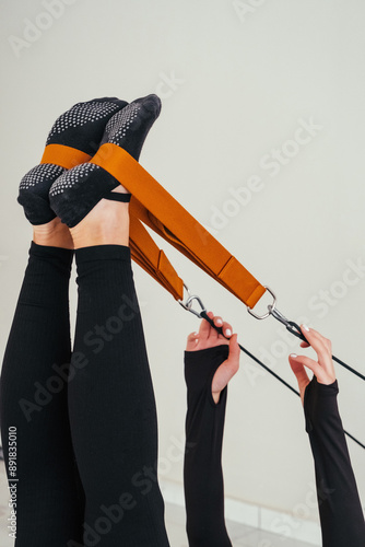 Mature woman doing Pilates exercise on pilates reformer bed 