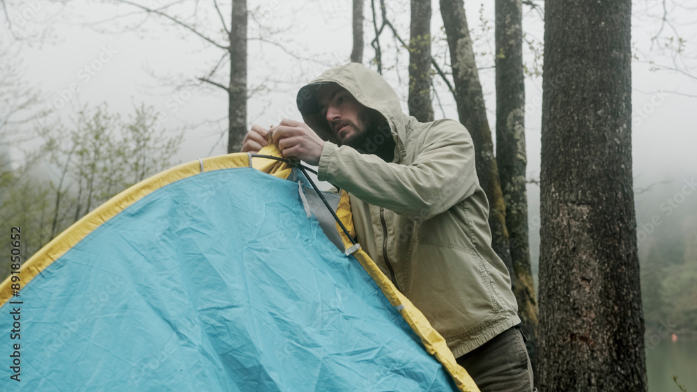 Man setting up tent outdoors. Hiker assembles campsite tent in the autumnal forest. Traveler installing tent in woods
Man setting up tent outdoors. Hiker assembles campsite tent in the autumnal forest. Traveler installing tent in woods