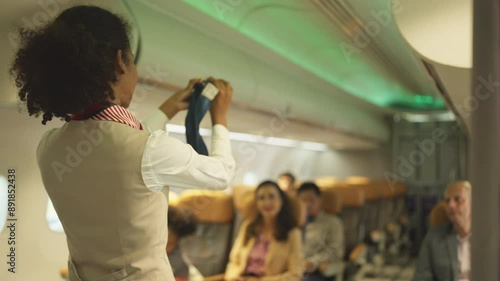Back of Airline staff woman demonstration and explain about safety tools, safety belt, in the airplane to the passenger before the flight in airport area.