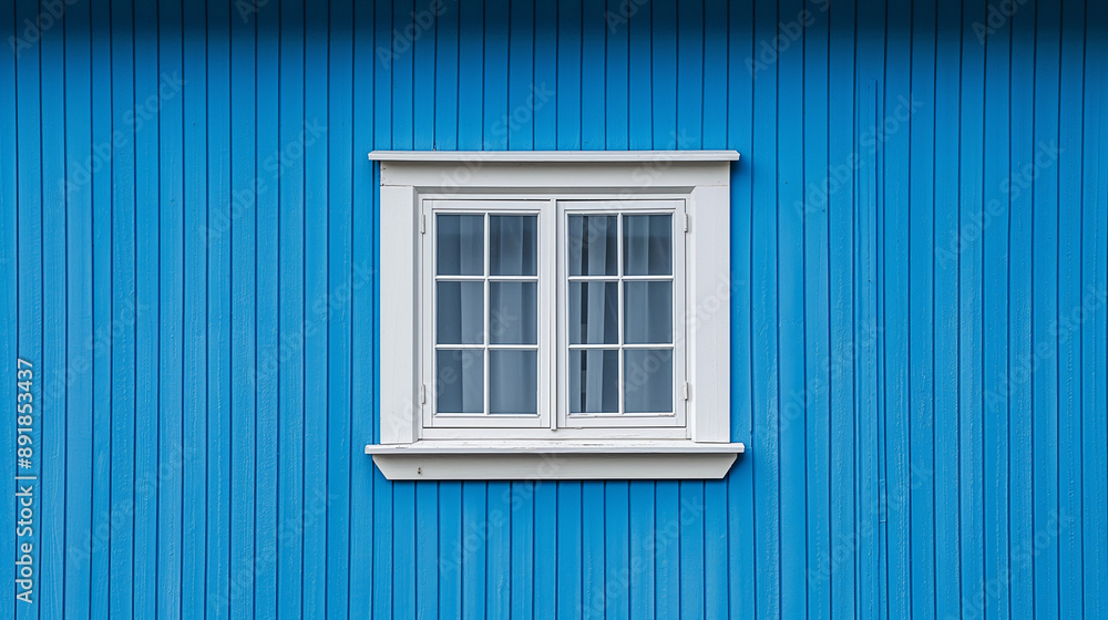 Fototapeta premium A vibrant blue wall with vertical ridges. Positioned centrally on this wall is a white window with six panes. The window has a white frame and appears to be slightly ajar