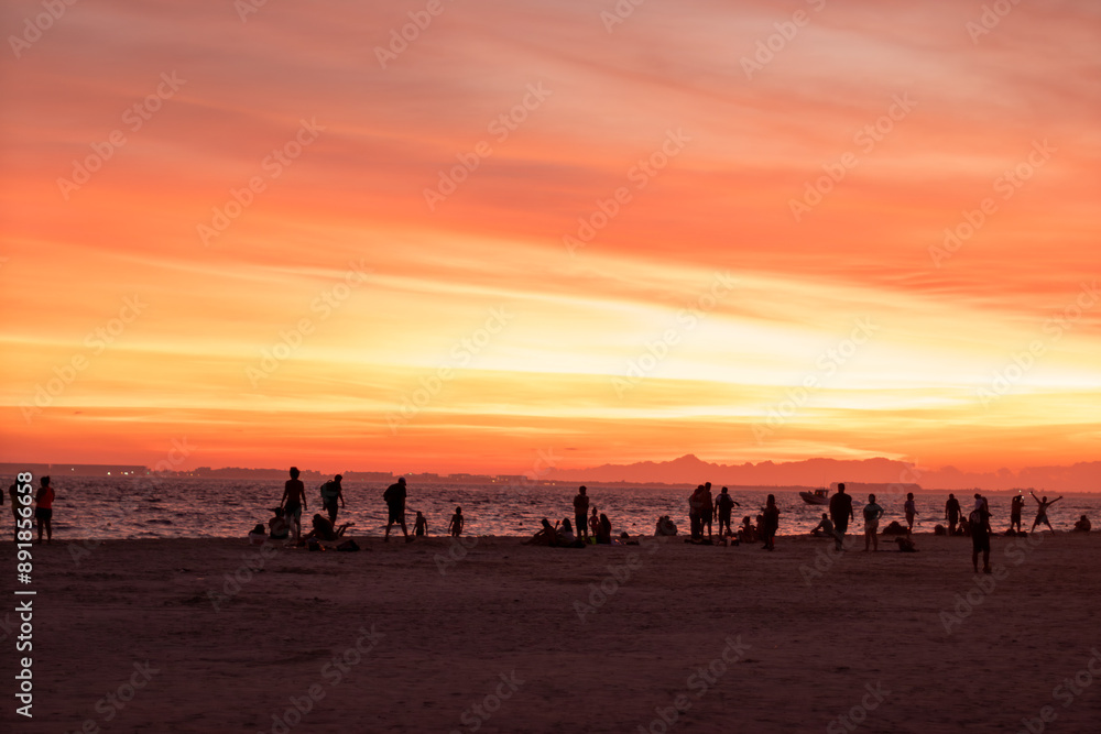 people gathering at the beach at sunset people gathering at the beach at sunset