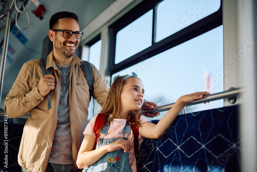 Little girl and her father enjoying in city bus ride. photo