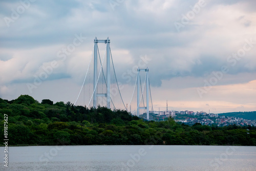 Suspension Bridge Spanning Over Lush Green Landscape with Urban Skyline in the Background. Osmangazi Bridge, sea and forest view.