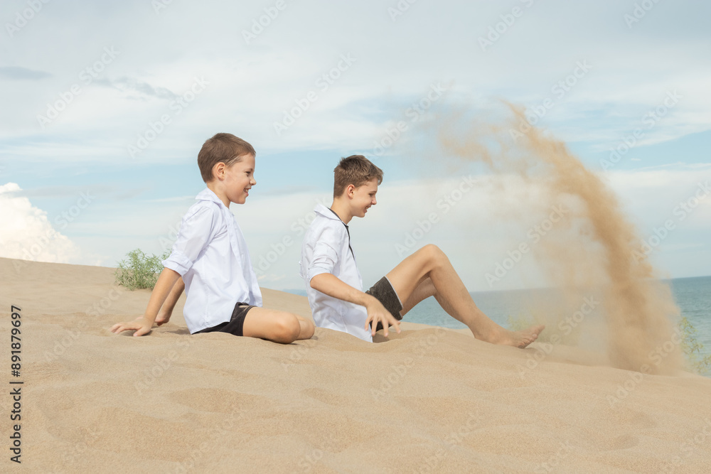 Two Boys Playing with Sand on Beach: Childhood Adventure and Time Metaphor by Ocean Shore Two Boys Playing with Sand on Beach: Childhood Adventure and Time Metaphor by Ocean Shore