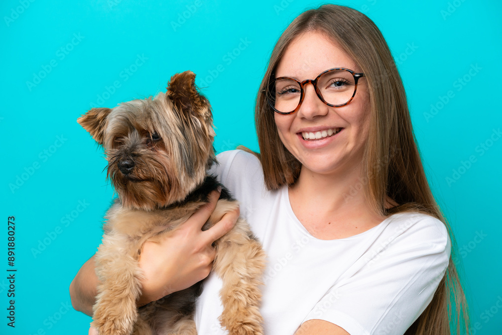 Young Lithuanian woman holding a dog isolated on blue background Young Lithuanian woman holding a dog isolated on blue background