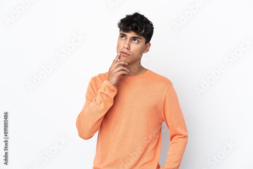 Young man over isolated white background having doubts photo