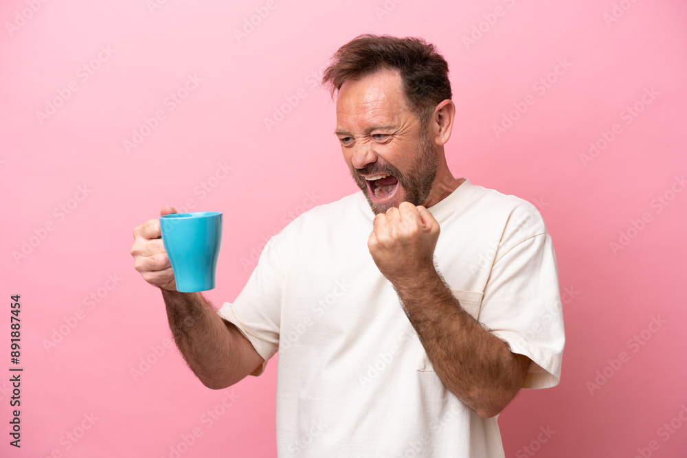 Middle age caucasian man holding cup of coffee isolated on pink background celebrating a victory Middle age caucasian man holding cup of coffee isolated on pink background celebrating a victory