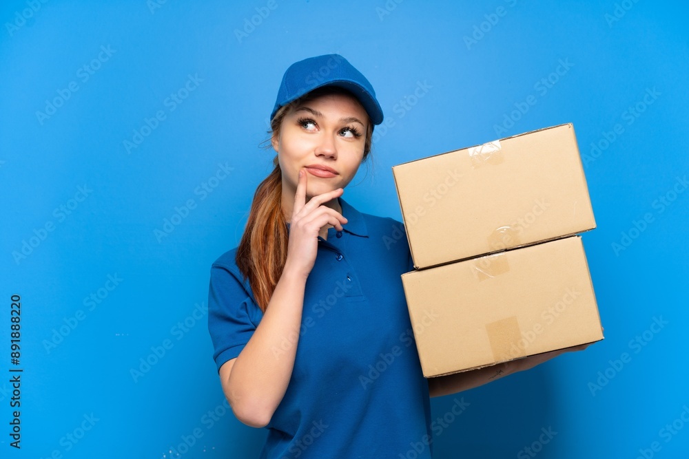 Delivery girl over isolated blue wall having doubts while looking up Delivery girl over isolated blue wall having doubts while looking up