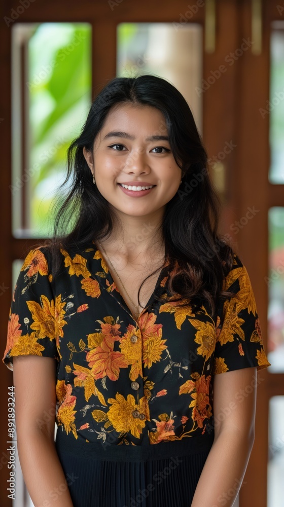 Young woman in a floral blouse smiling at the camera Young woman in a floral blouse smiling at the camera
