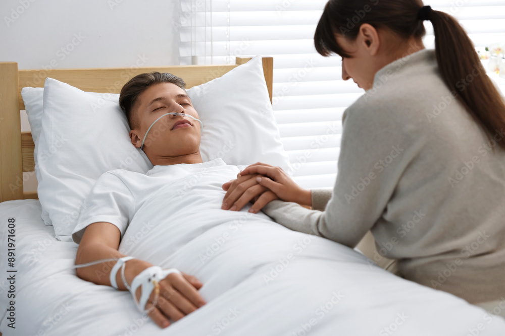 Coma patient. Sad young woman near her husband in hospital Coma patient. Sad young woman near her husband in hospital