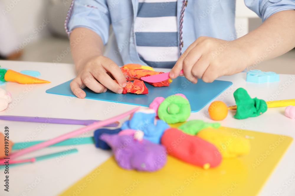 Little boy sculpting with play dough at table indoors, closeup Little boy sculpting with play dough at table indoors, closeup