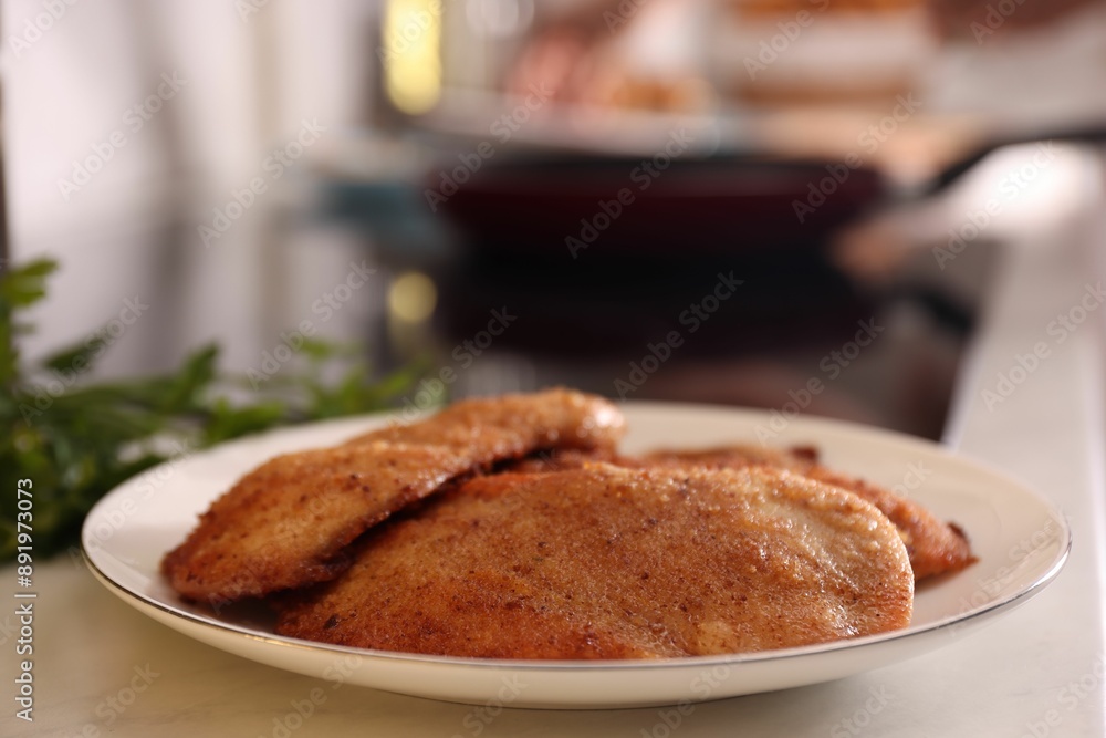 Plate of tasty schnitzels on table in kitchen, closeup Plate of tasty schnitzels on table in kitchen, closeup