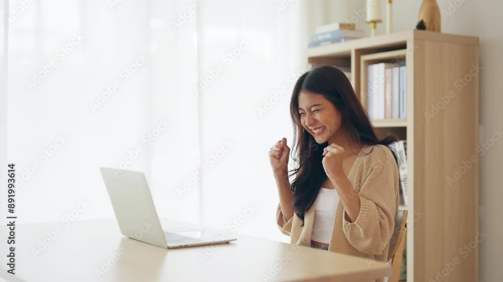 Funny euphoric young asian woman celebrating winning or getting ecommerce shopping offer on computer laptop. Excited happy girl winner looking at notebook celebrating success Funny euphoric young asian woman celebrating winning or getting ecommerce shopping offer on computer laptop. Excited happy girl winner looking at notebook celebrating success