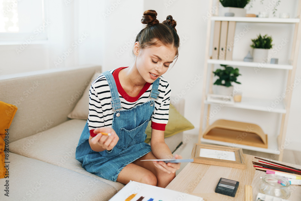 Happy teenage girl artist at home, painting and creating artwork on a cute indoor studio sofa. Happy teenage girl artist at home, painting and creating artwork on a cute indoor studio sofa.
