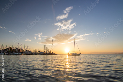 Fantastic sunset on a large lake. Standing on the shore looking to the horizon across the lake into the sun. Romantic landscape shot at Lake Balaton, Hungary