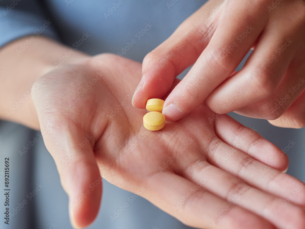 家にいる子供が薬の錠剤を持つ様子 家にいる子供が薬の錠剤を持つ様子