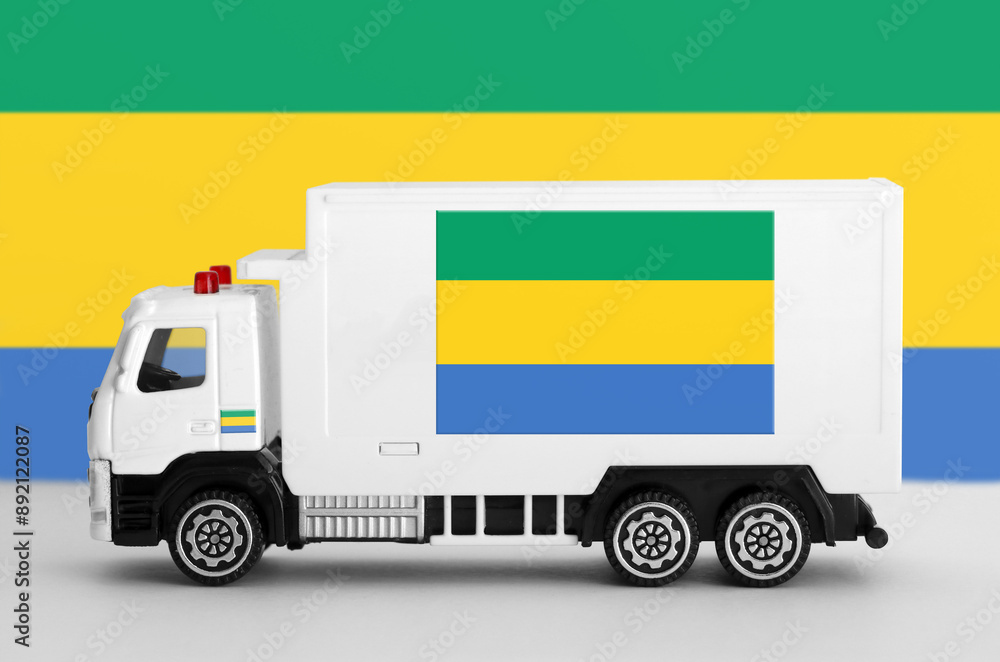 Gabon flag depicted on side wall of white delivery van close up. Shipping and local delivery concept Gabon flag depicted on side wall of white delivery van close up. Shipping and local delivery concept