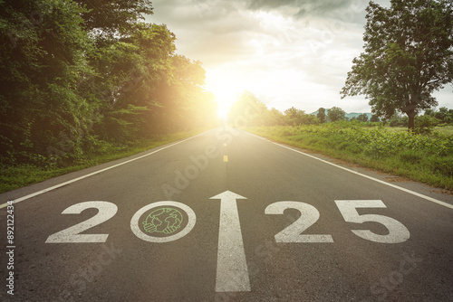 New year 2025 straightforward for business sustainability goals concept. Text 2025 and save the world, environment protection icon on the road in the middle of asphalt road at sunset. Green business. photo