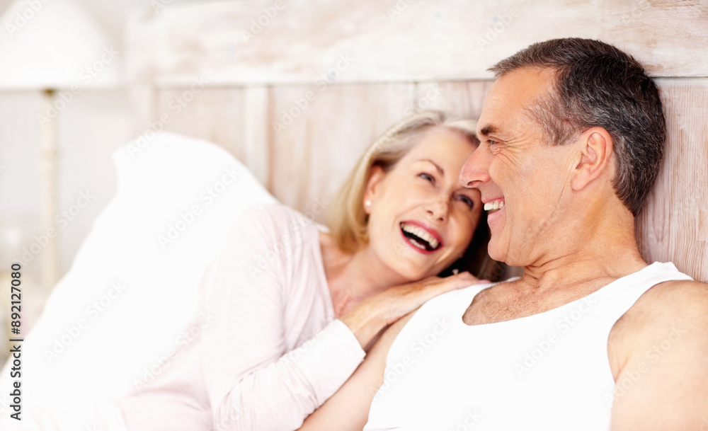 Fototapeta premium Mature couple, laugh and relax in bed at house for hug, love and retirement together with trust and care. Man, woman and cuddle in hotel bedroom for marriage, loyalty or tired on weekend with smile