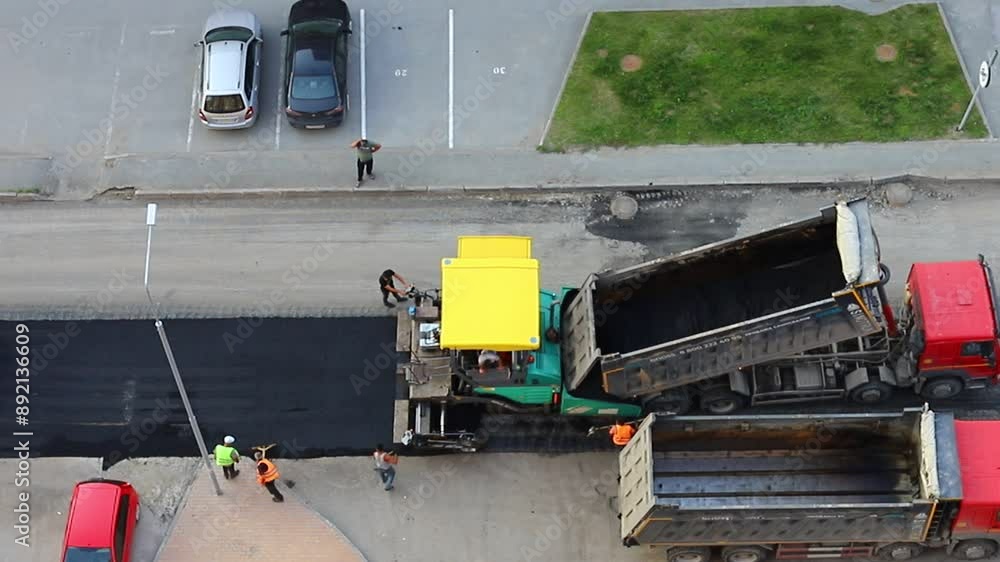 Road surface repair works. The paver is laying new asphalt. Road surface repair works. The paver is laying new asphalt.