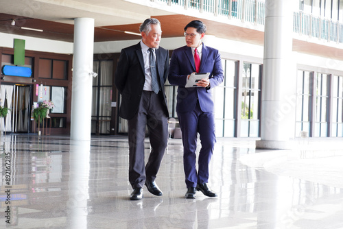 Businessmen walking and talking about work in the office business idea.